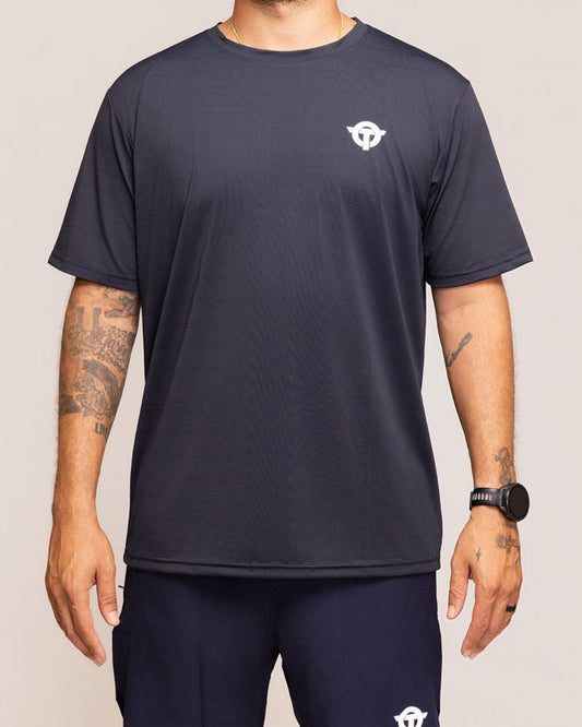 Man wearing a dark blue athletic outfit with a logo on a plain background