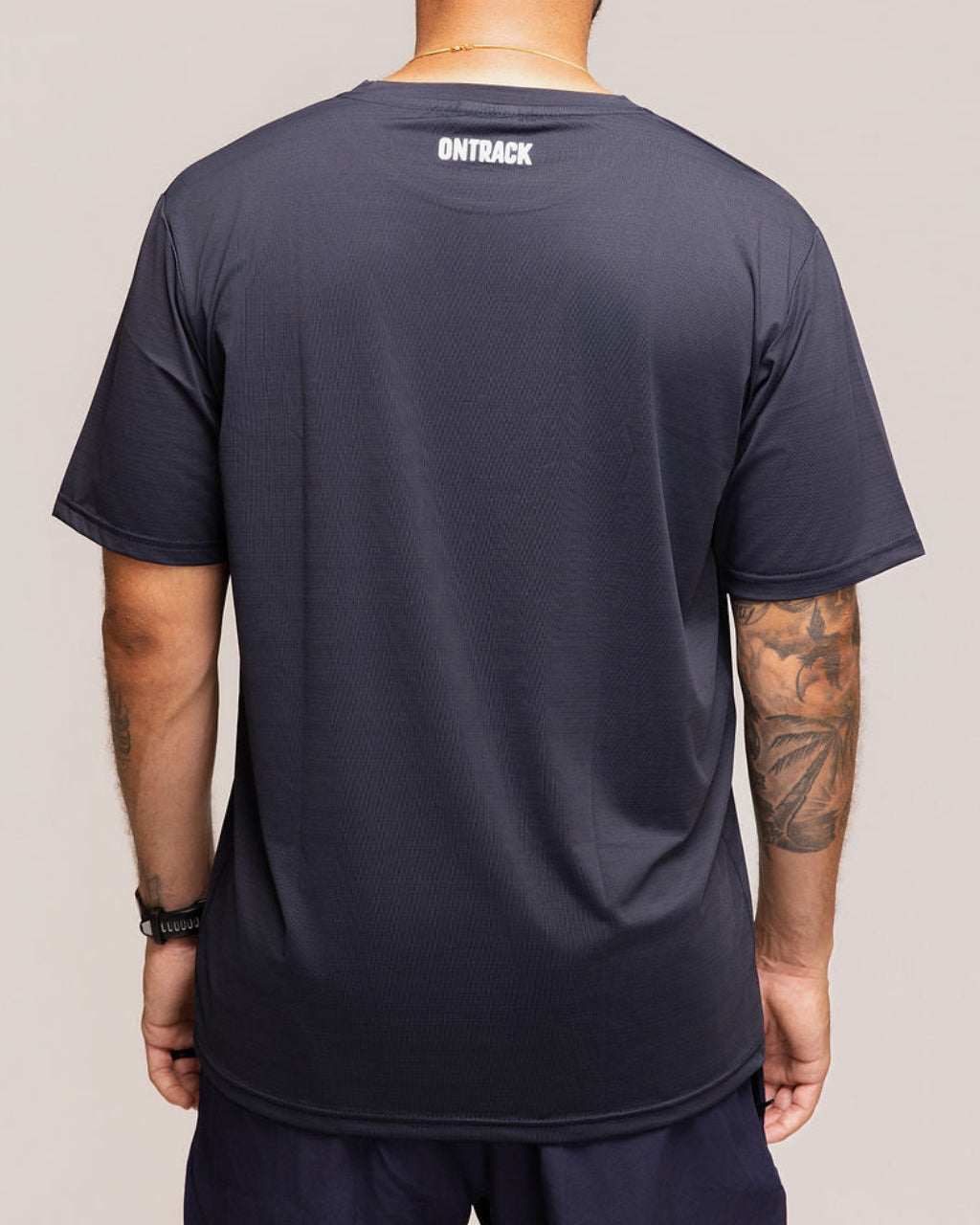 Man wearing a black t-shirt with 'OnTrack' branding on the back, standing against a plain background.