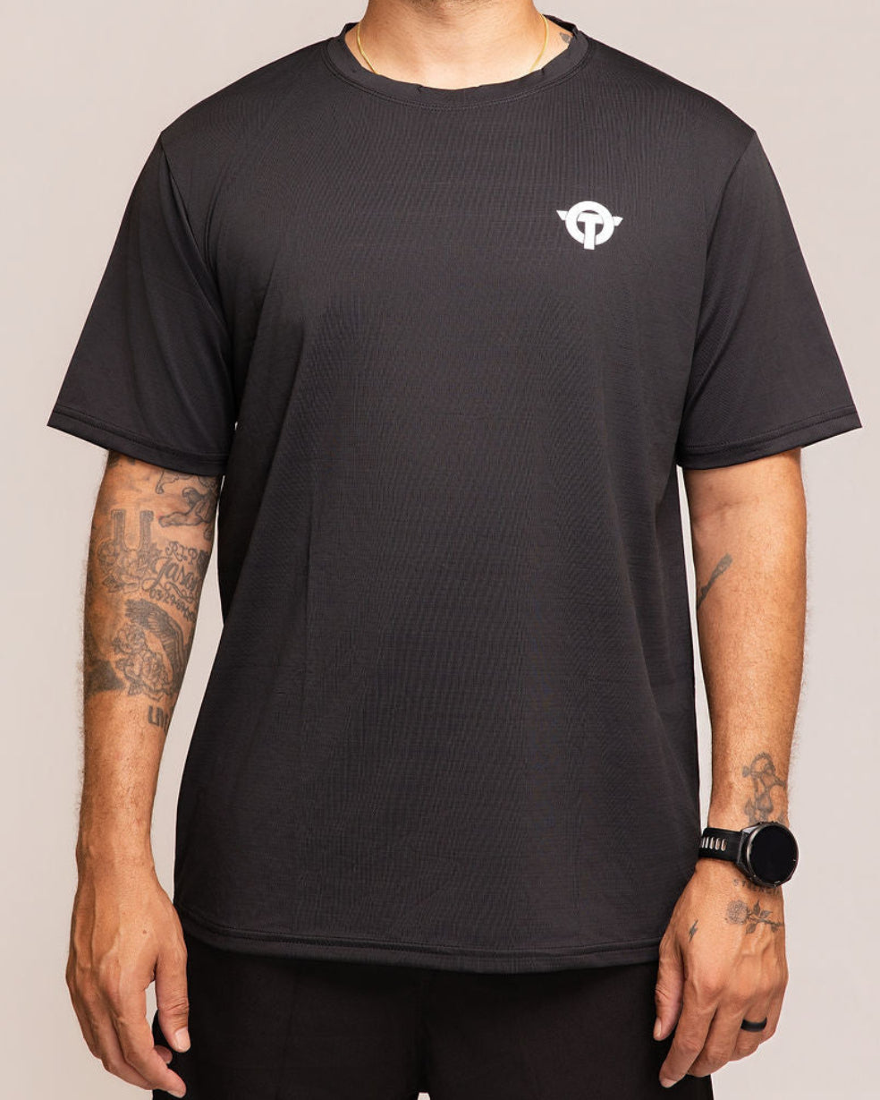 Man wearing a black t-shirt with a logo on a beige background